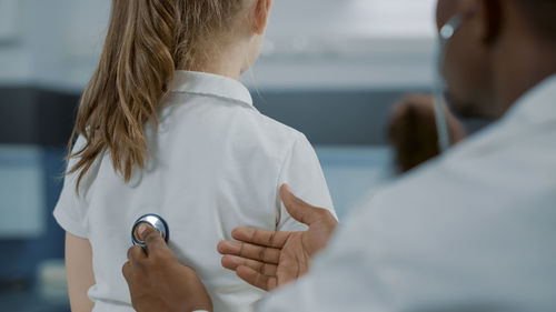 Midsection of doctor examining patient in hospital