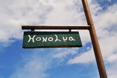 Low angle view of road sign against sky