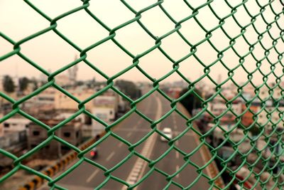 Full frame shot of chainlink fence against townscape