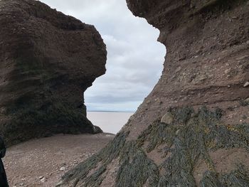 Rock formations by sea against sky