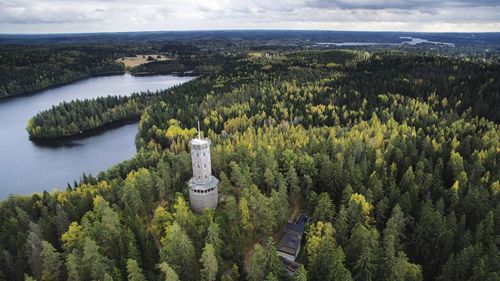 High angle view of tower in green trees in river