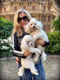 Portrait of woman carrying dogs in city