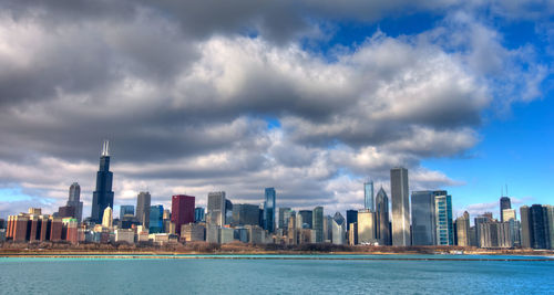 View of city buildings against cloudy sky