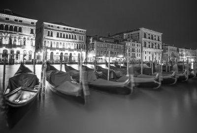 View of boats moored in canal at night