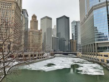 Bridge over river in city during winter