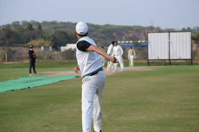 Rear view of man standing on golf course