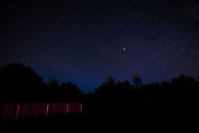 Low angle view of silhouette trees against sky at night