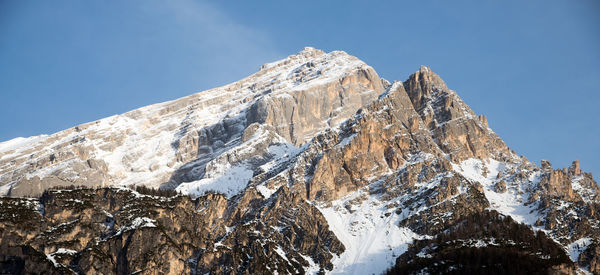 Low angle view of snowcapped mountain against sky