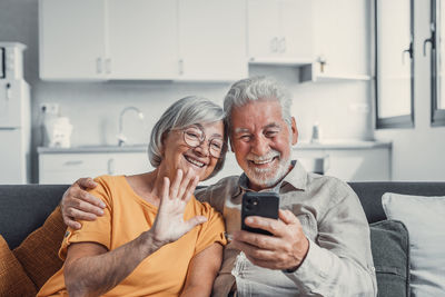 Young woman using mobile phone while sitting at home