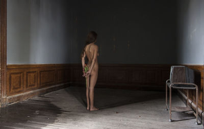 Naked woman standing in abandoned house