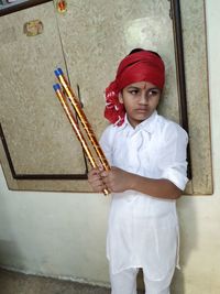 Close-up of boy standing against wall