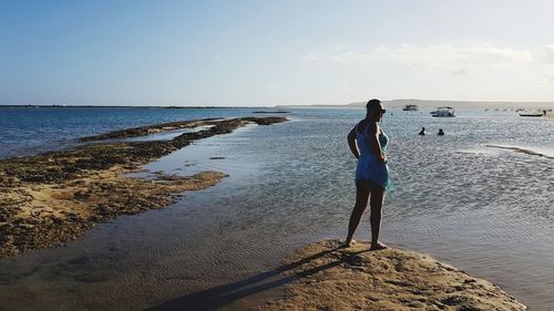 Girl on beach against sky