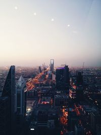 Aerial view of illuminate cityscape against sky at dusk