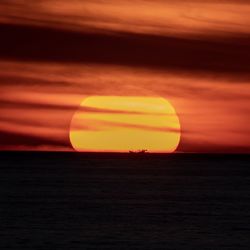 Scenic view of sea against romantic sky at sunset