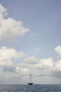 Sailboat sailing on sea against sky