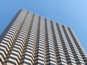 Low angle view of modern building against clear blue sky