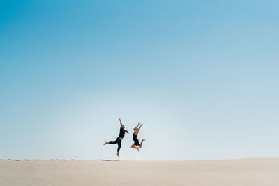 People in desert against sky