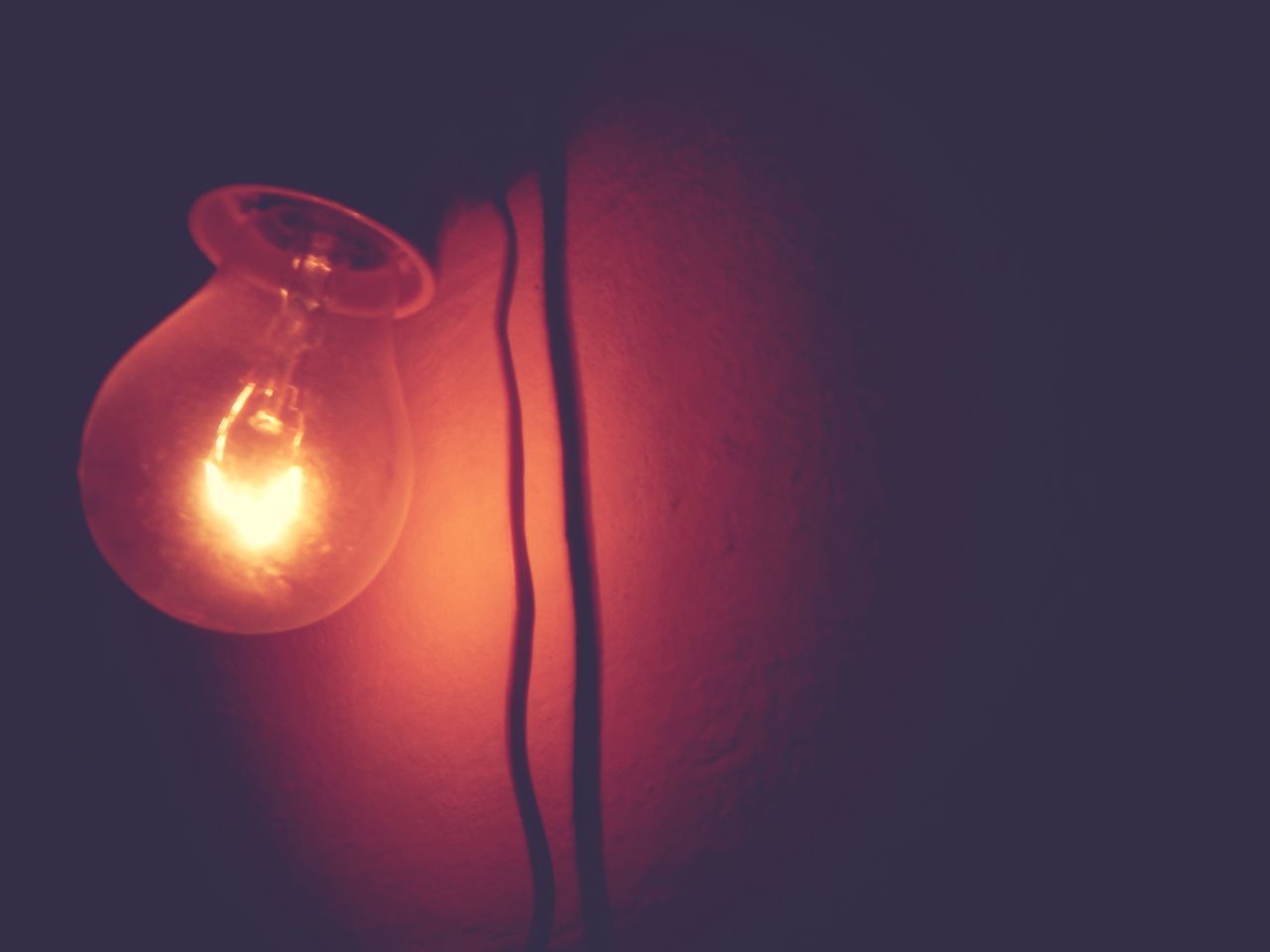 electricity, light bulb, lighting equipment, illuminated, filament, indoors, glowing, light, darkness, red, no people, incandescent light bulb, studio shot, close-up, copy space, electric light, power generation, light - natural phenomenon, single object, technology, yellow, macro photography, circle, glass, dark, power supply, electric lamp, lighting