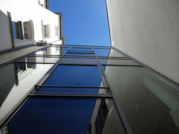 Low angle view of modern building against clear blue sky