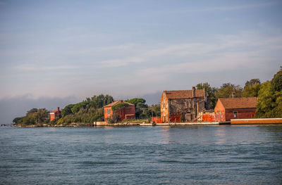 Scenic view of sea by buildings against sky