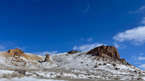 Scenic view of snowcapped mountains against blue sky