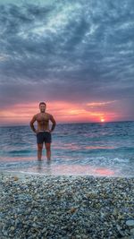 Silhouette of woman standing on beach at sunset