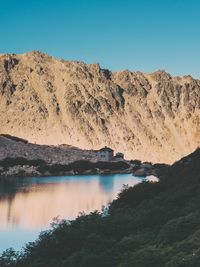 Scenic view of lake and mountains against clear blue sky
