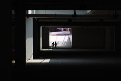 Silhouette people walking in corridor of building