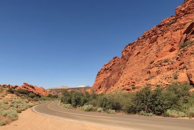 Landscape of road leading between red rock hills in snow canyon state park in utah