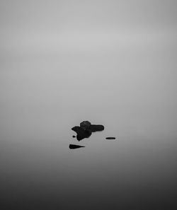 Silhouette of floating on sea against sky