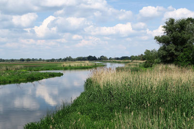 Scenic view of lake against cloudy sky