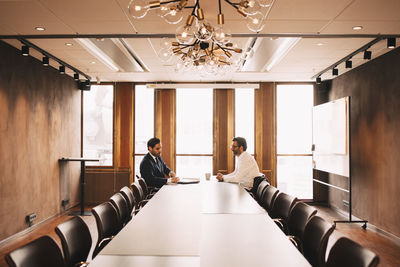 Financial advisor discussing with client in board room at law office