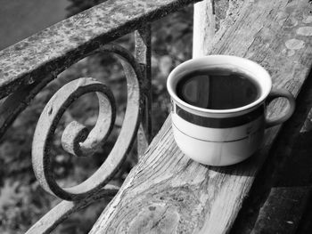 High angle view of coffee cup on railing