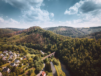 High angle view of trees on landscape with viaduct railroad against sky