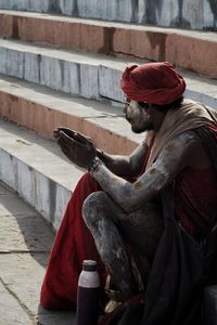 Close-up of sadhu sitting on staircase