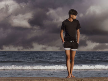 Full length of man standing on beach against sky