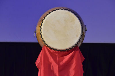 Red fabric hanging from traditional drum