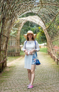 Portrait of a smiling woman standing on footpath