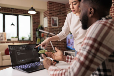 Midsection of man using laptop at office