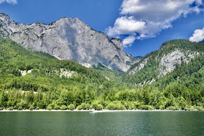 Scenic view of lake by mountains against sky