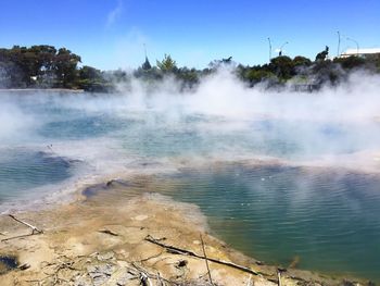 Scenic view of steam emitting from geyser against sky