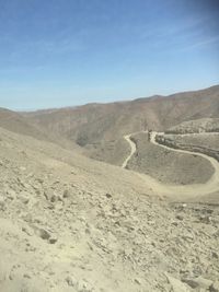 Scenic view of desert against clear blue sky