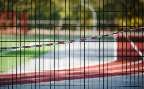 Red and white prohibitory tape on the fence of the sports complex. closed for visiting, quarantine