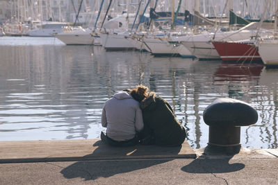 Rear view of woman sitting on sailboat in lake