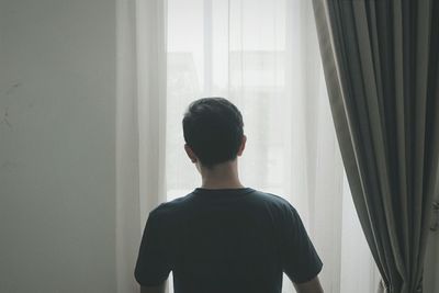 Close-up of woman standing against white wall