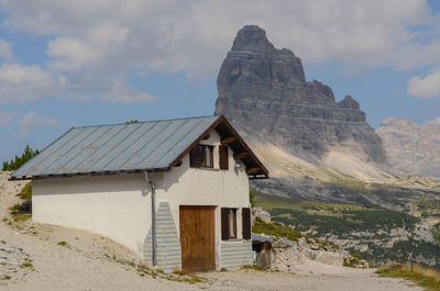 Built structure on landscape against cloudy sky