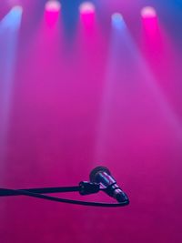 Close-up of microphone on stand against lights