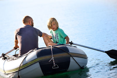 Father and son traveling in boat on sea