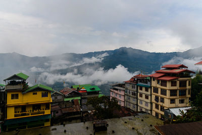 Buildings in city against cloudy sky