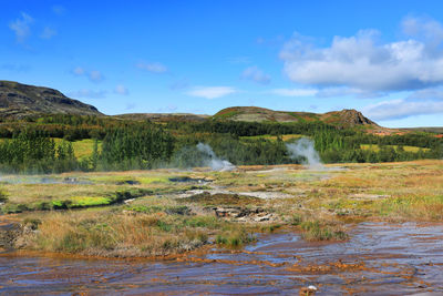 Scenic view of waterfall against sky